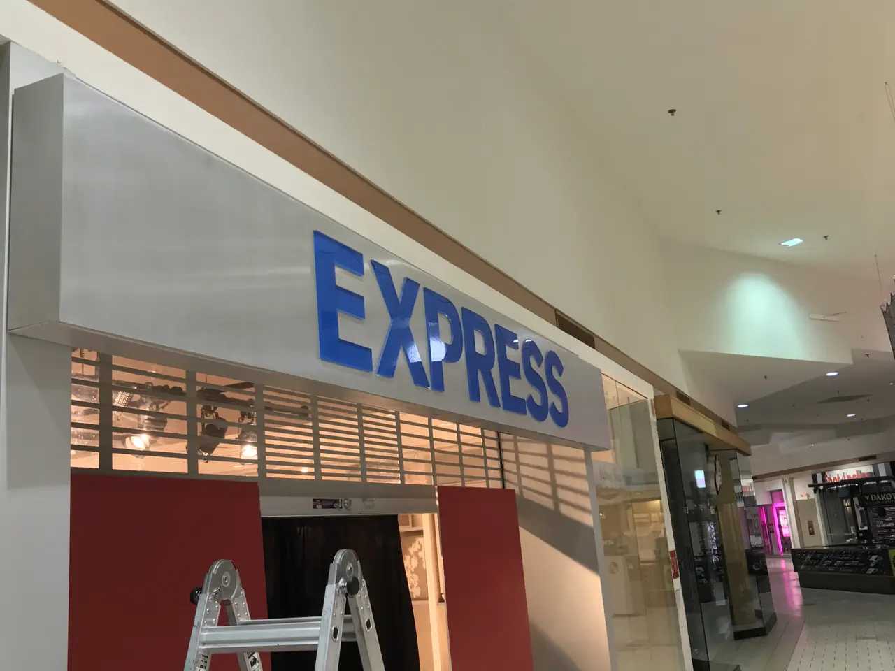 Express clothing store illuminated sign above a mall storefront entrance.