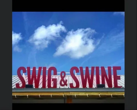 Swig & Swine stand‑up letters mounted on top of a roof awning entrance.
