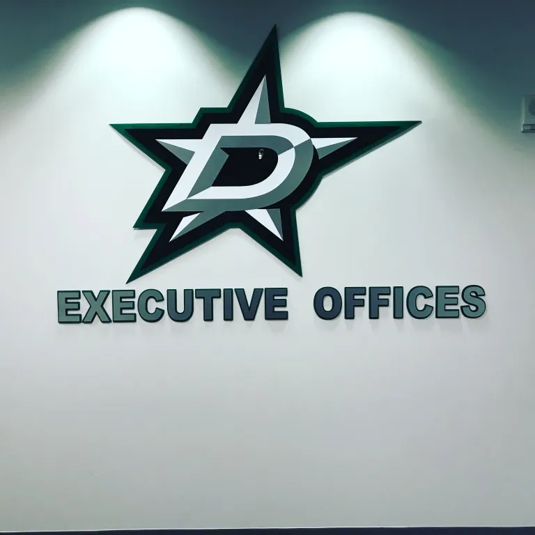 Executive Offices dimensional logo sign installed on a smooth interior wall with subtle lighting and neutral tones.