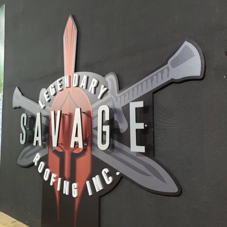 Legendary Savage Roofing custom cut sign with silver three‑dimensional letters mounted on a dark textured panel.