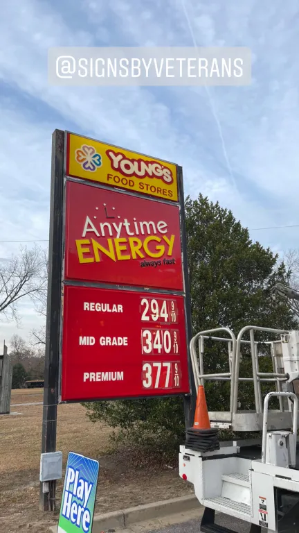 Anytime Energy gas station price sign with illuminated digital fuel pricing at night.