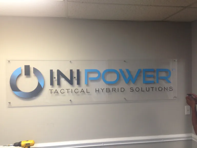 Inipower Tactical Hybrid Solutions acrylic wall sign with stand‑offs mounted on an interior wall.