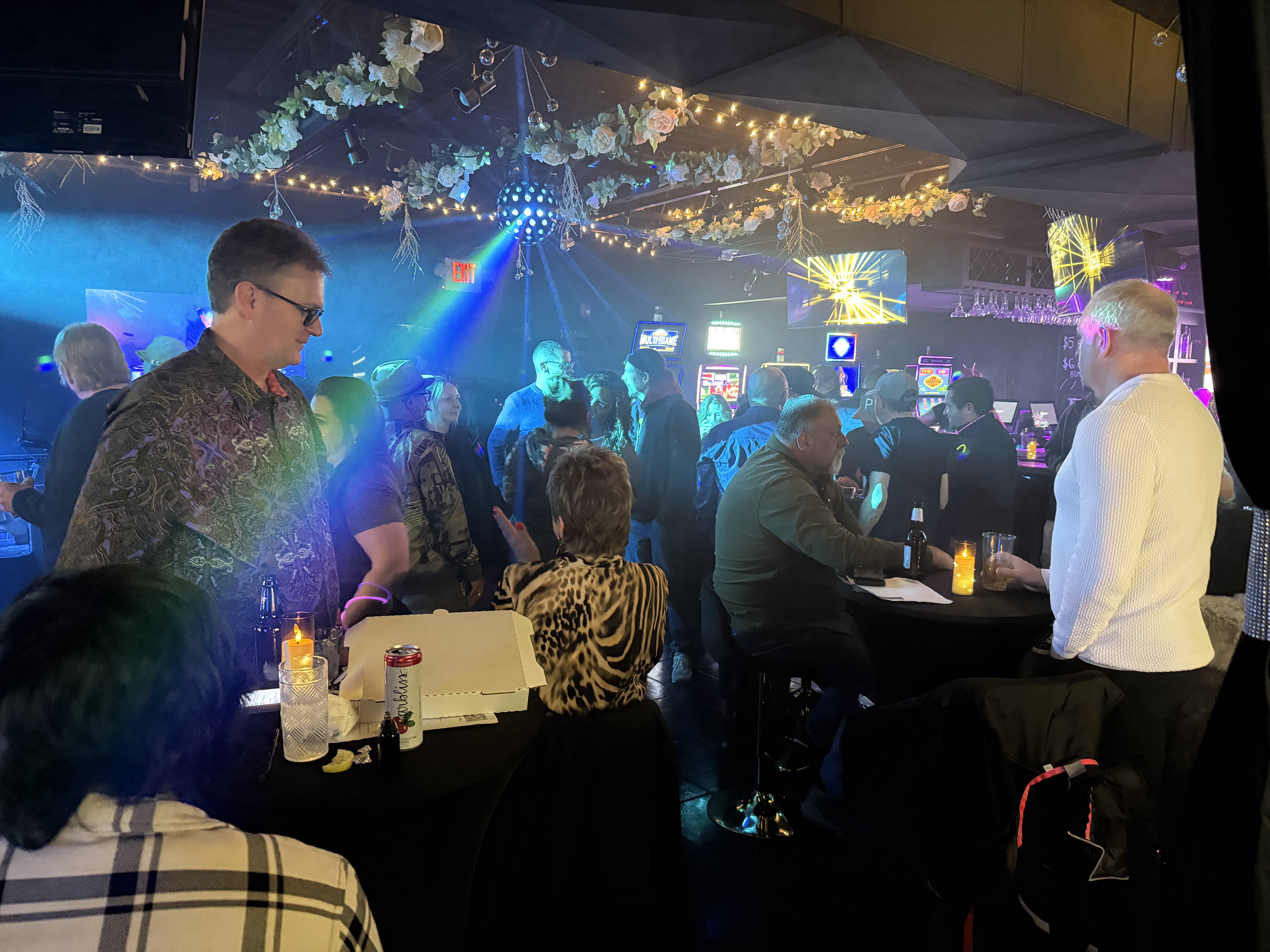 Evening crowd under floral decor and disco ball
