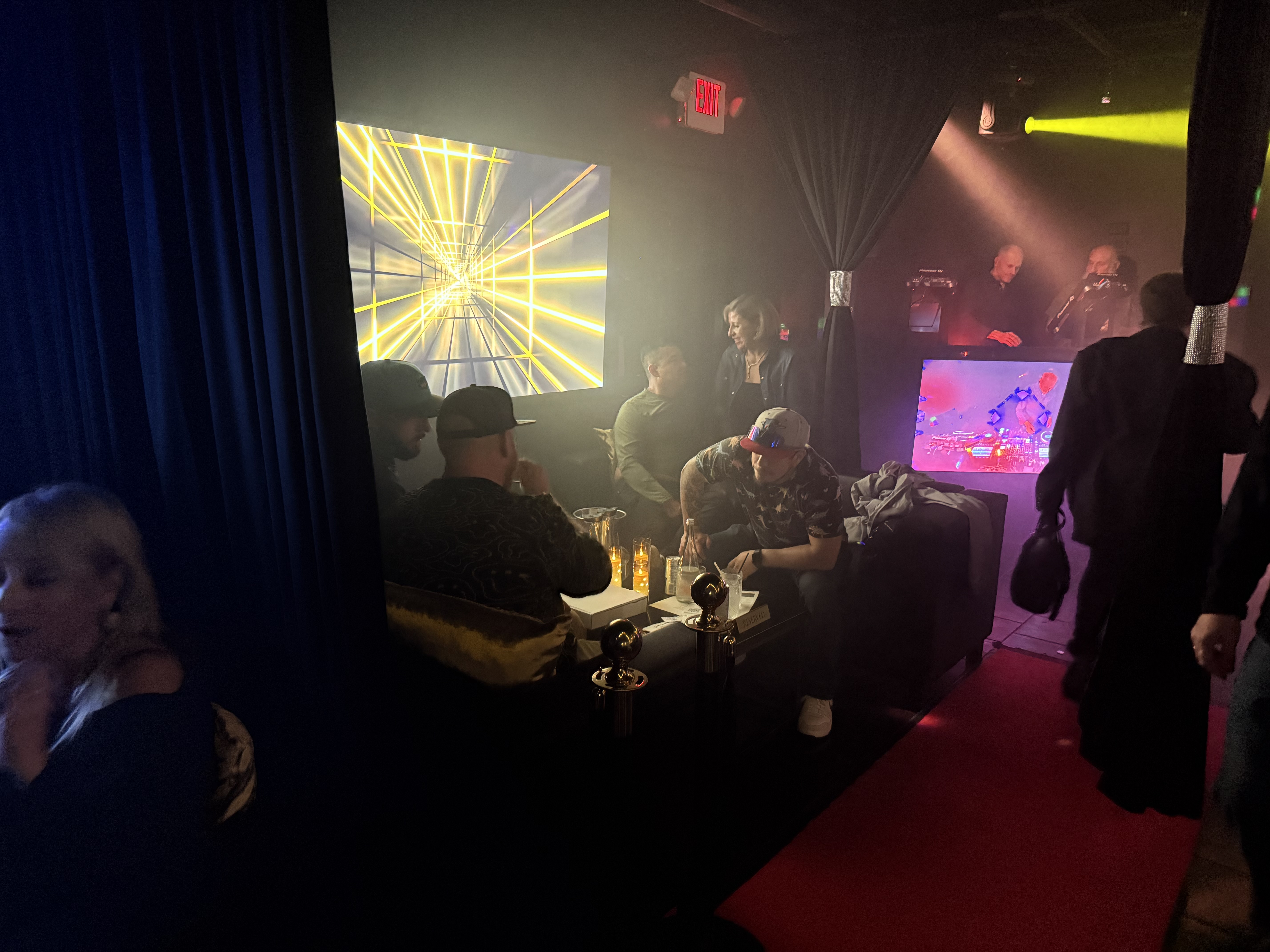 Guests relaxing in a red-carpet VIP lounge at Black Velvet Lounge
