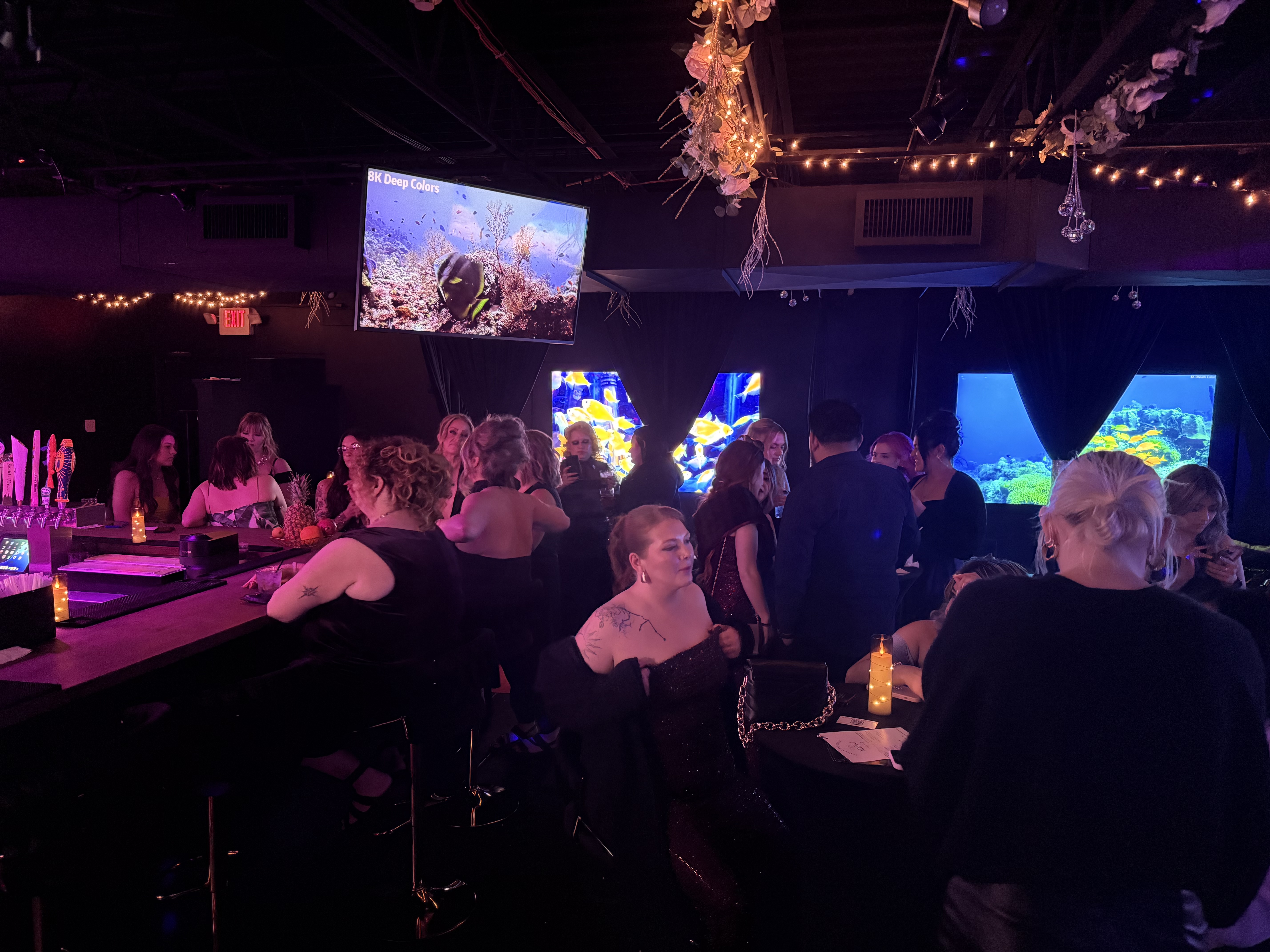 Guests at the bar with ambient aquarium screens
