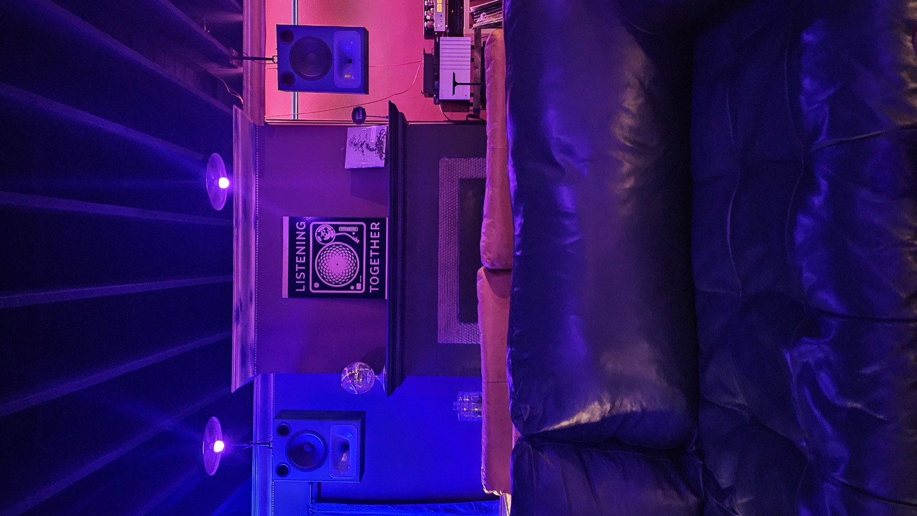 Leather couches facing the fireplace and the Listening Together poster