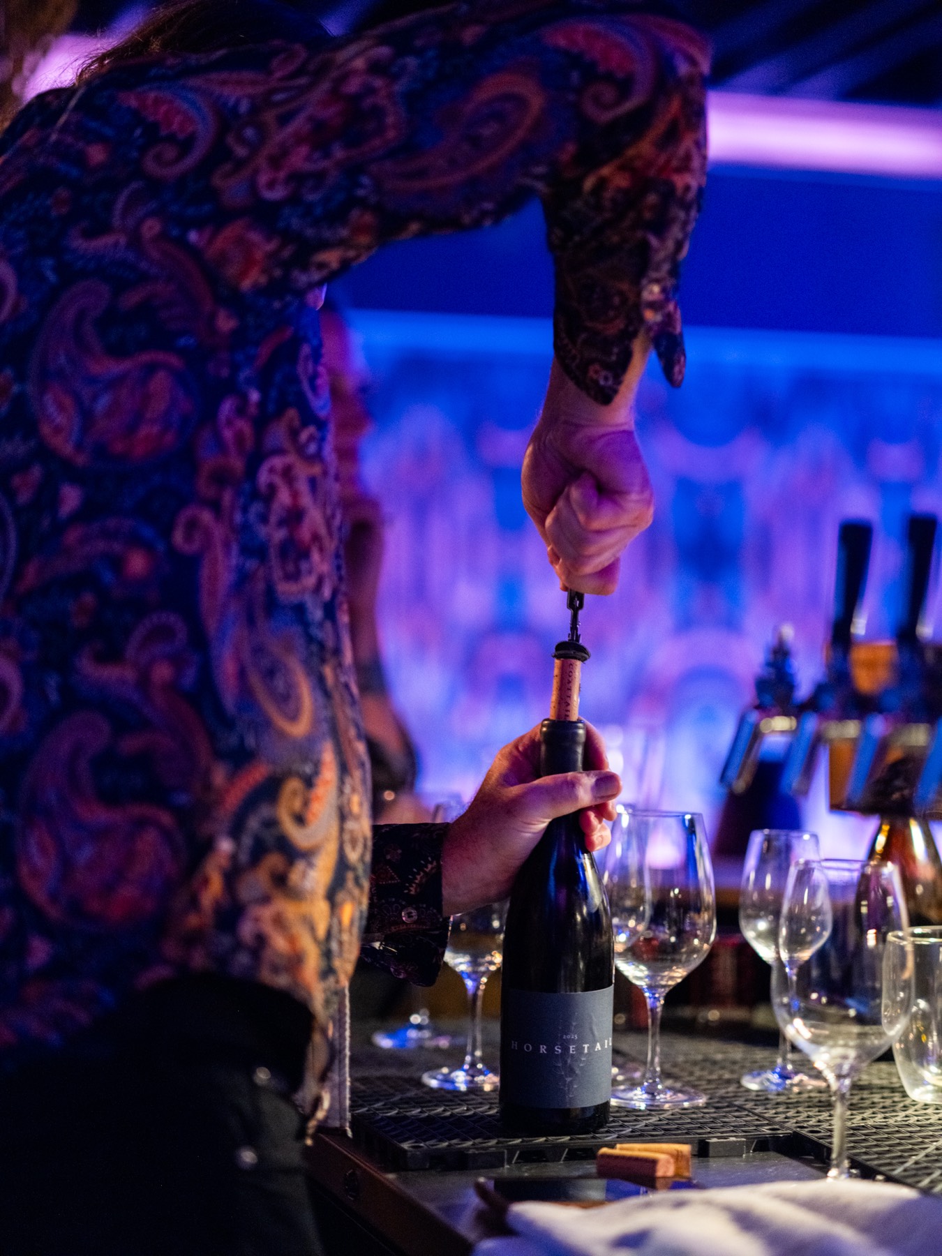 A bottle of wine being opened at the bar