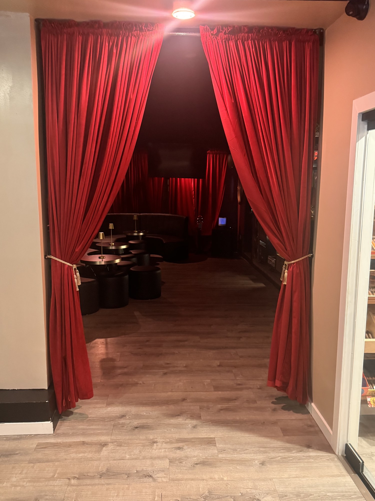 Red velvet curtains opening onto the private lounge