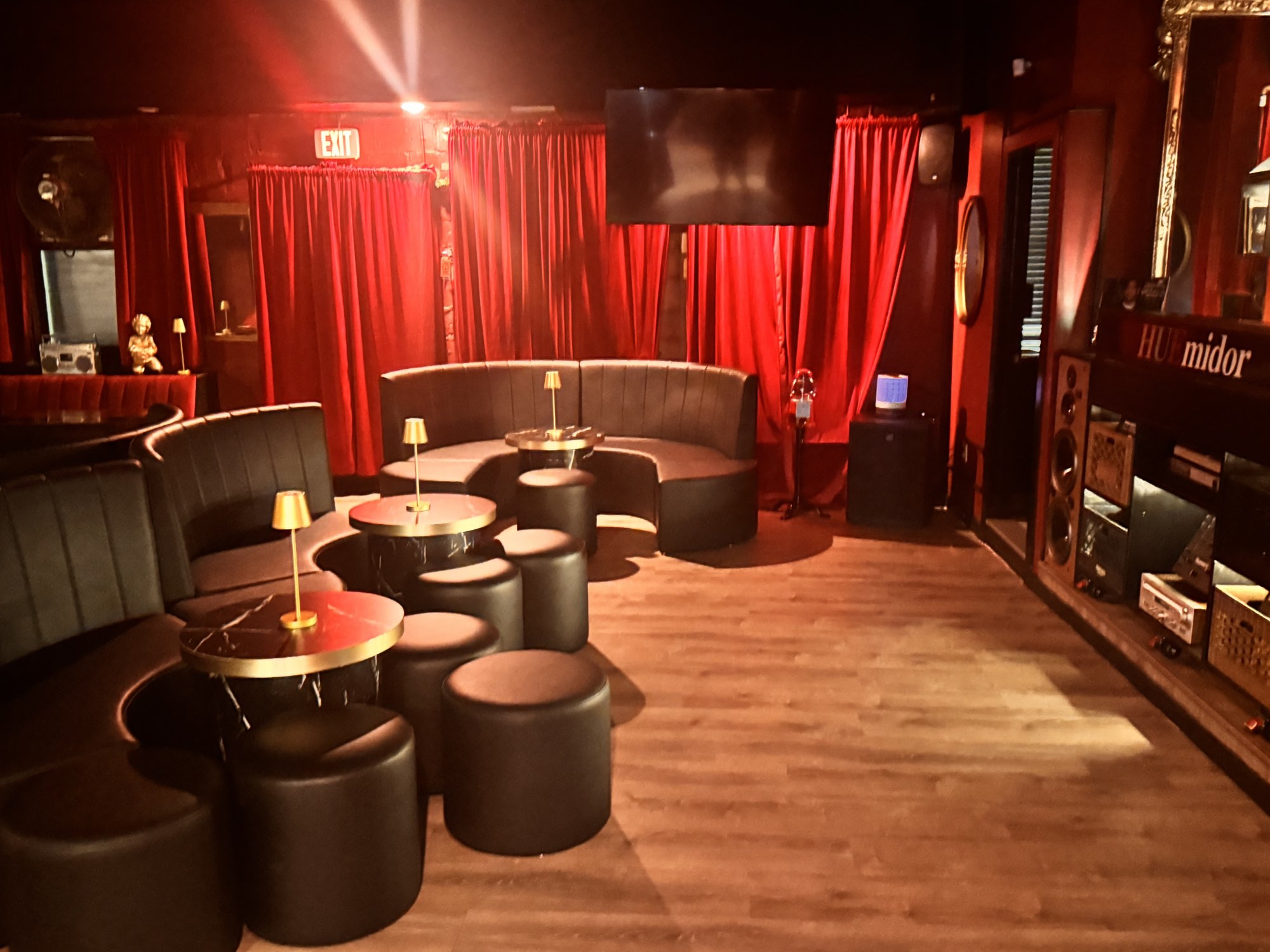 The Huemidor lounge with red velvet curtains, curved leather booths and brass table lamps
