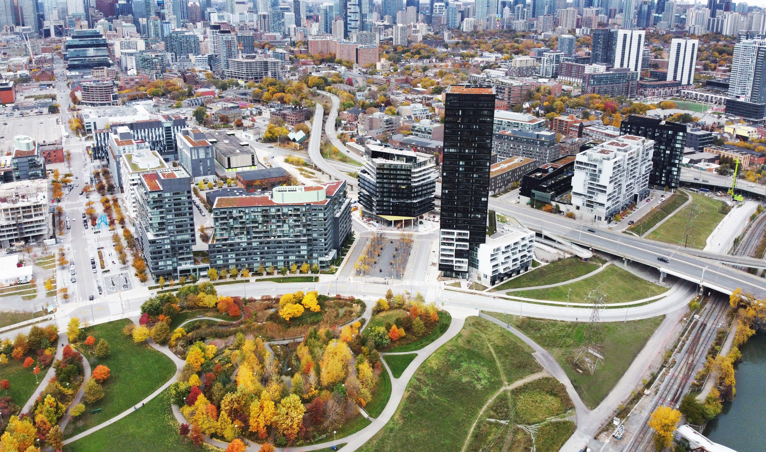 Aerial view of downtown Toronto showing modern urban development integrated with fall-colored parkland and waterfront infrastructure.