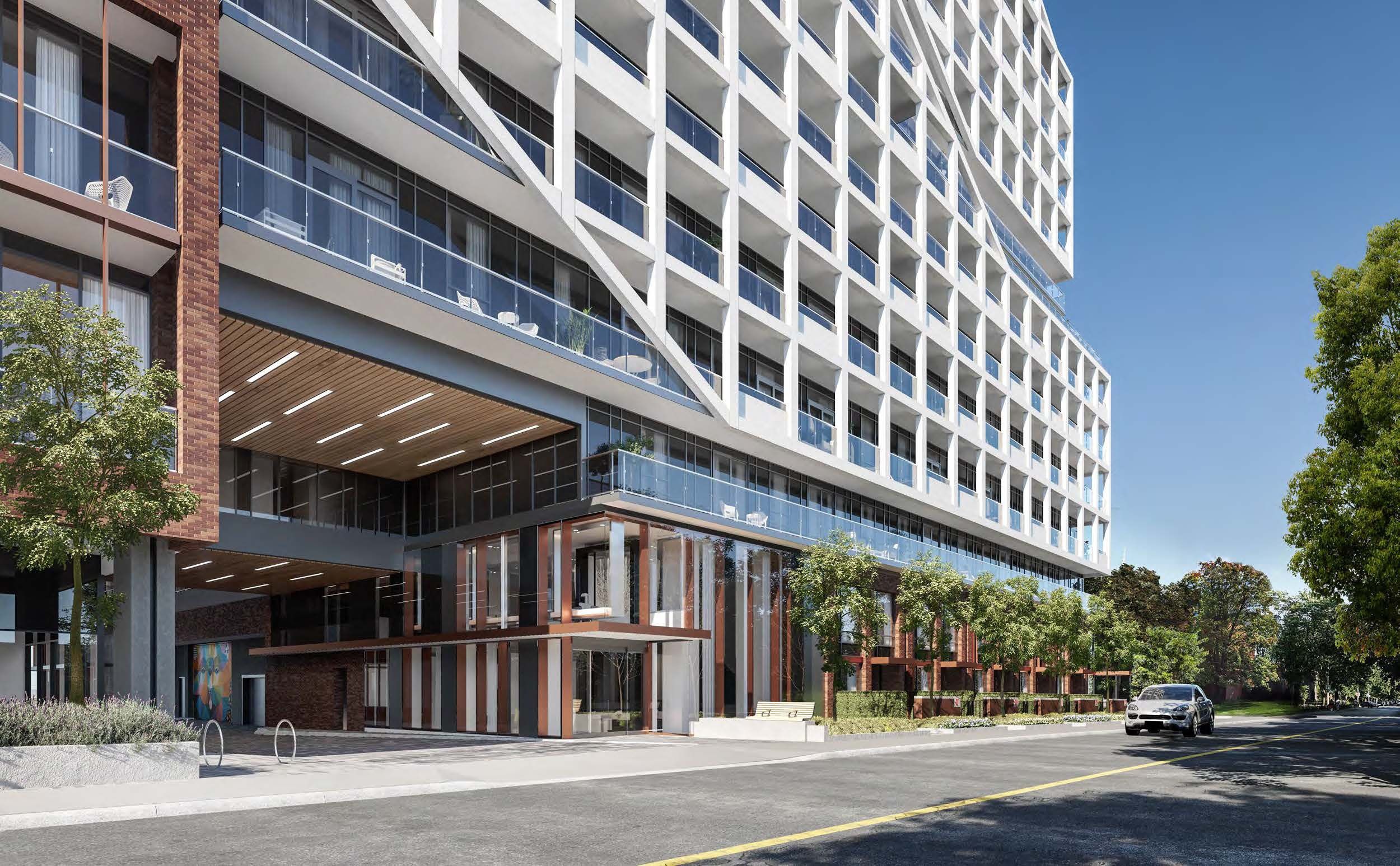 Modern mixed-use building featuring a white geometric facade with balconies, ground-floor retail spaces, and landscaped streetscape.