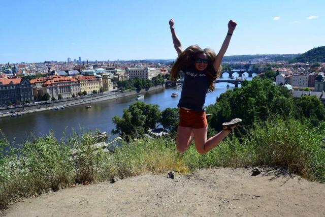 Teen traveler jumping in Prague on summer adventure travel program