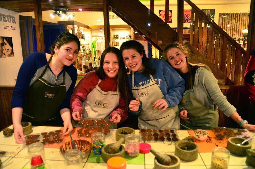 Things to do in Peru for teens. Group of teen girls cook a meal together during their summer trip to Peru.