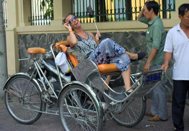 Teenage traveler having fun on rickshaw tour during summer youth travel program in Southeast Asia