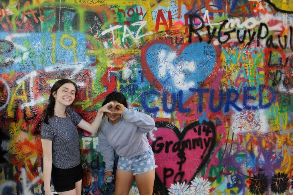 Teenage travelers at John Lennon Wall Prague on summer adventure travel program