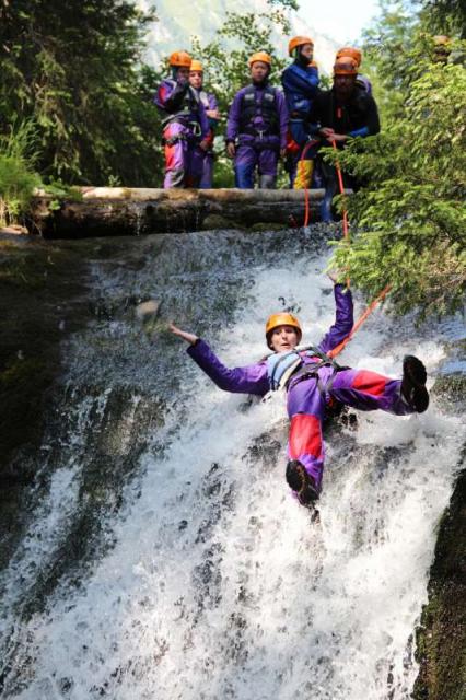 Teens canyoning in Swiss Alps on summer adventure travel program