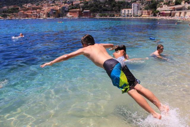 Teenage boy jumps into Mediterranean Sea during summer France language immersion program in French Riviera