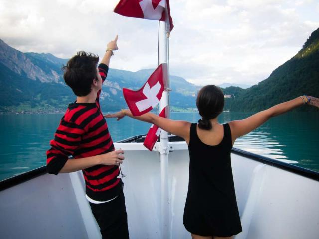 Teenage travelers cruising on Swiss lake Interlaken on summer travel program