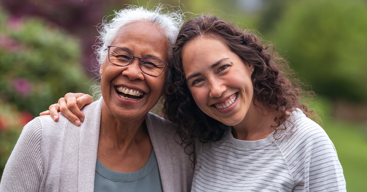 Woman smiling and hugging her elder mother