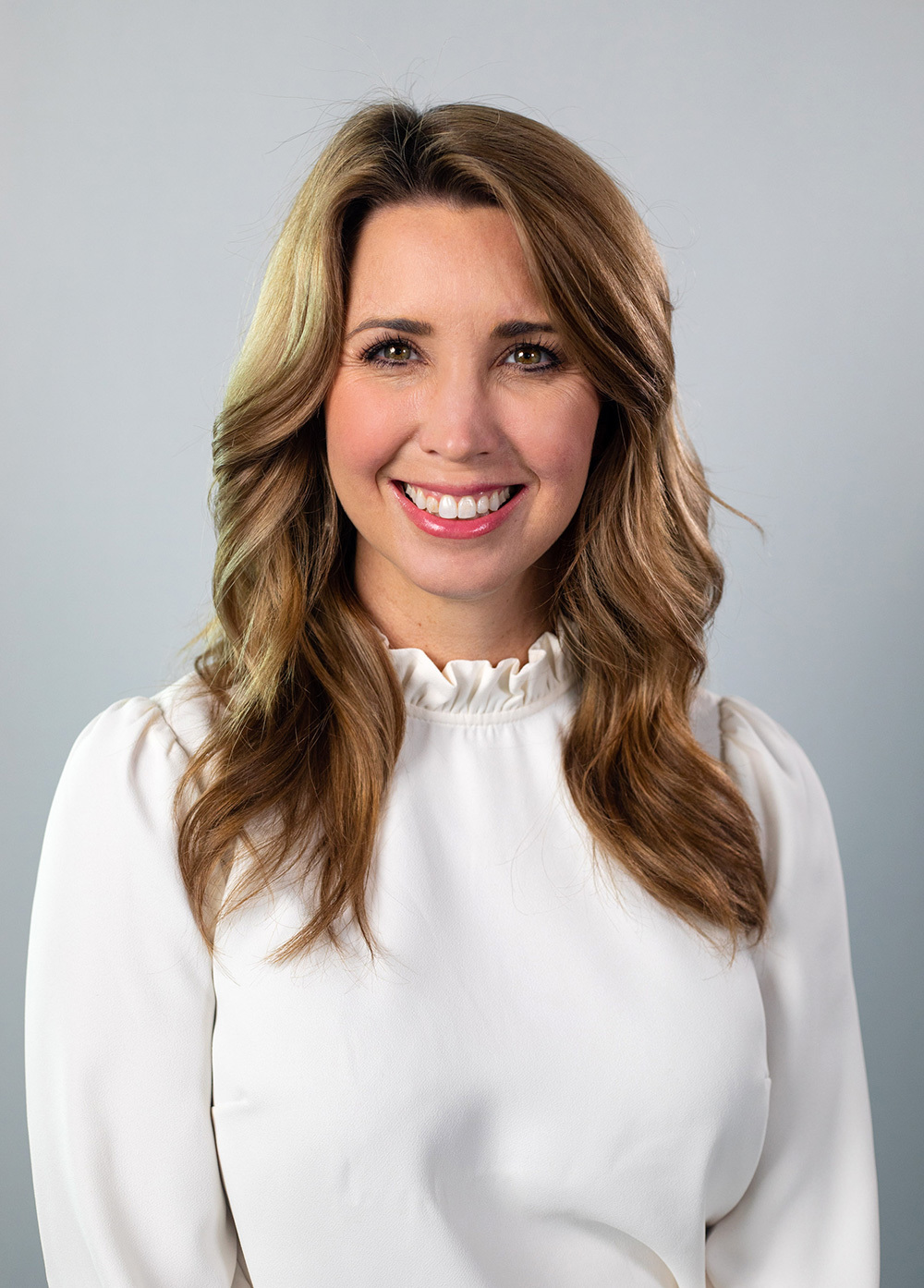 Social worker Krystle Pleitz, LCSW, wearing a white blouse and smiling in front of a white background.