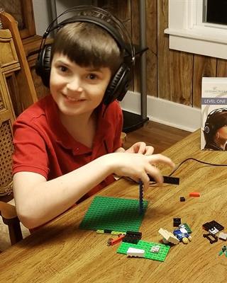 Mason wearing headphones at the table at home