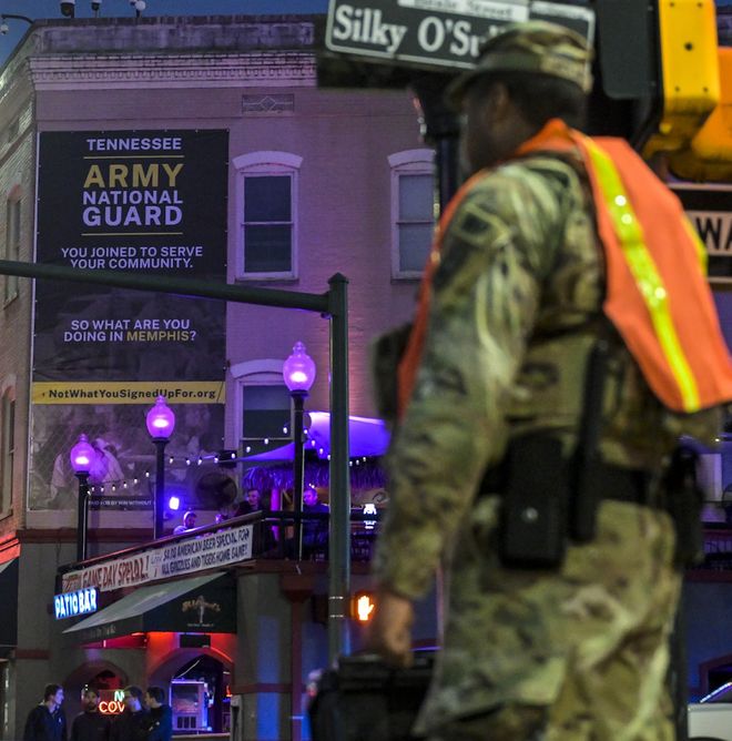 Image of a member of the National Guard standing in front of a WWW billboard in Memphis, TN